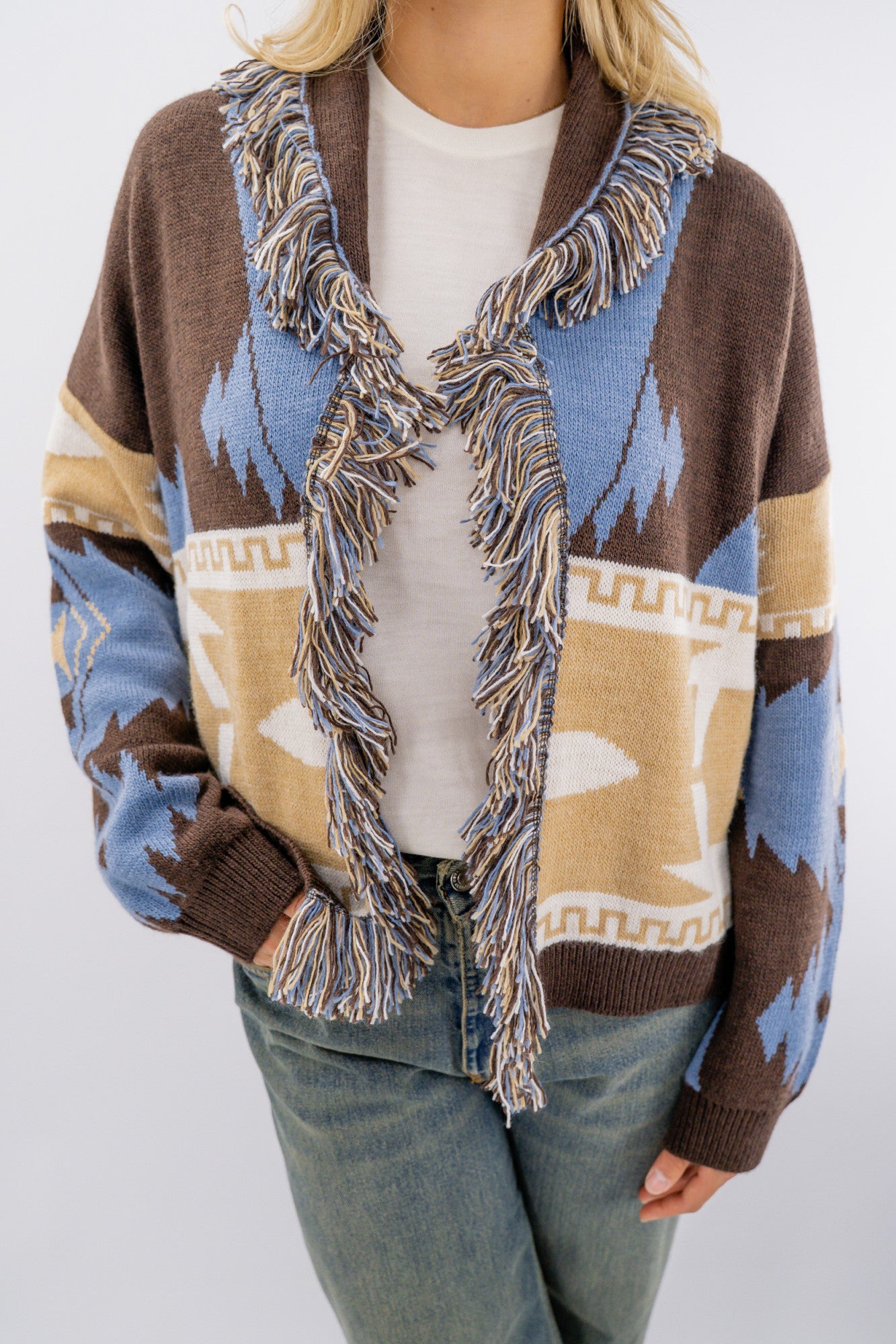 Cardigan aperto sciallato con frange.