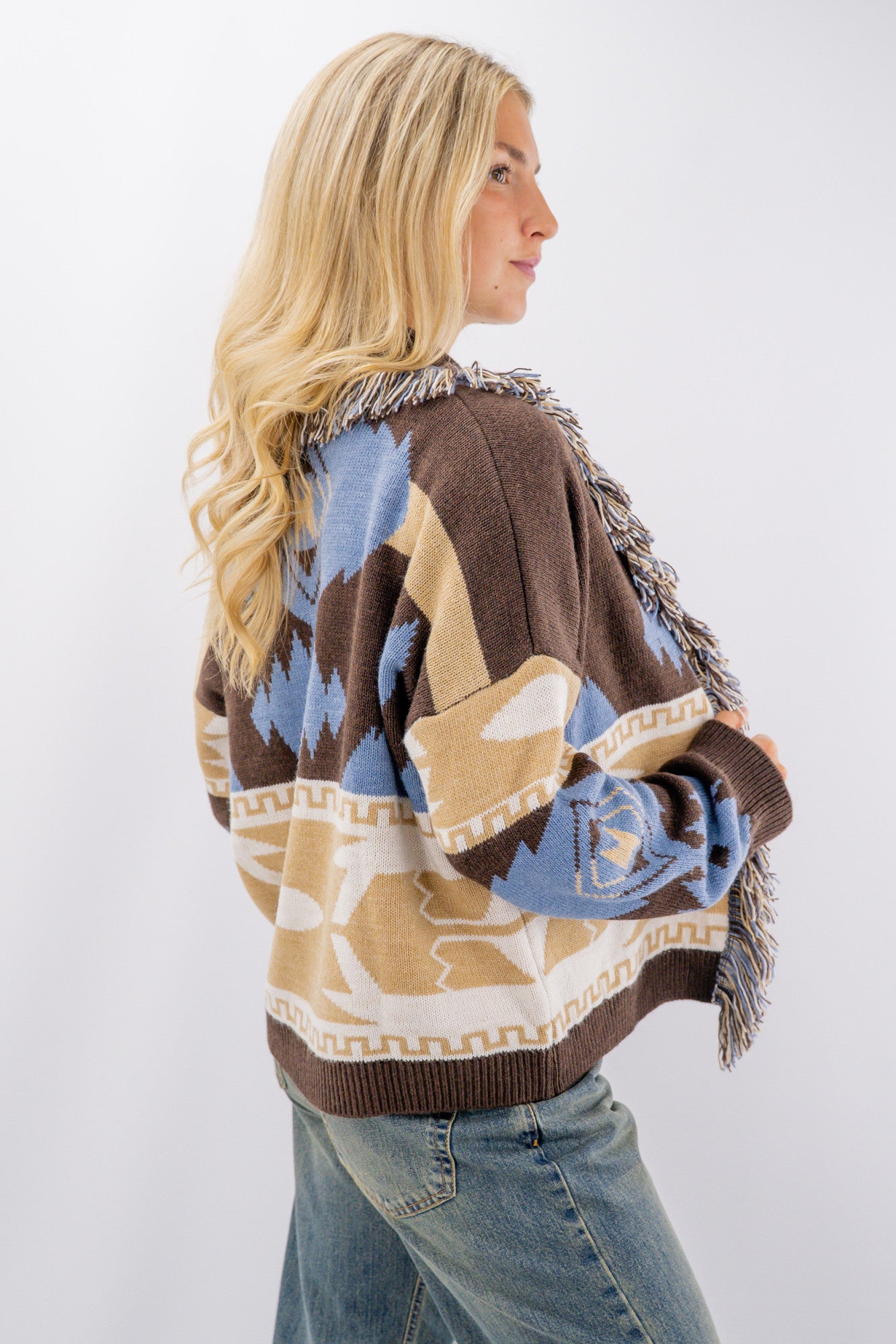 Cardigan aperto sciallato con frange.