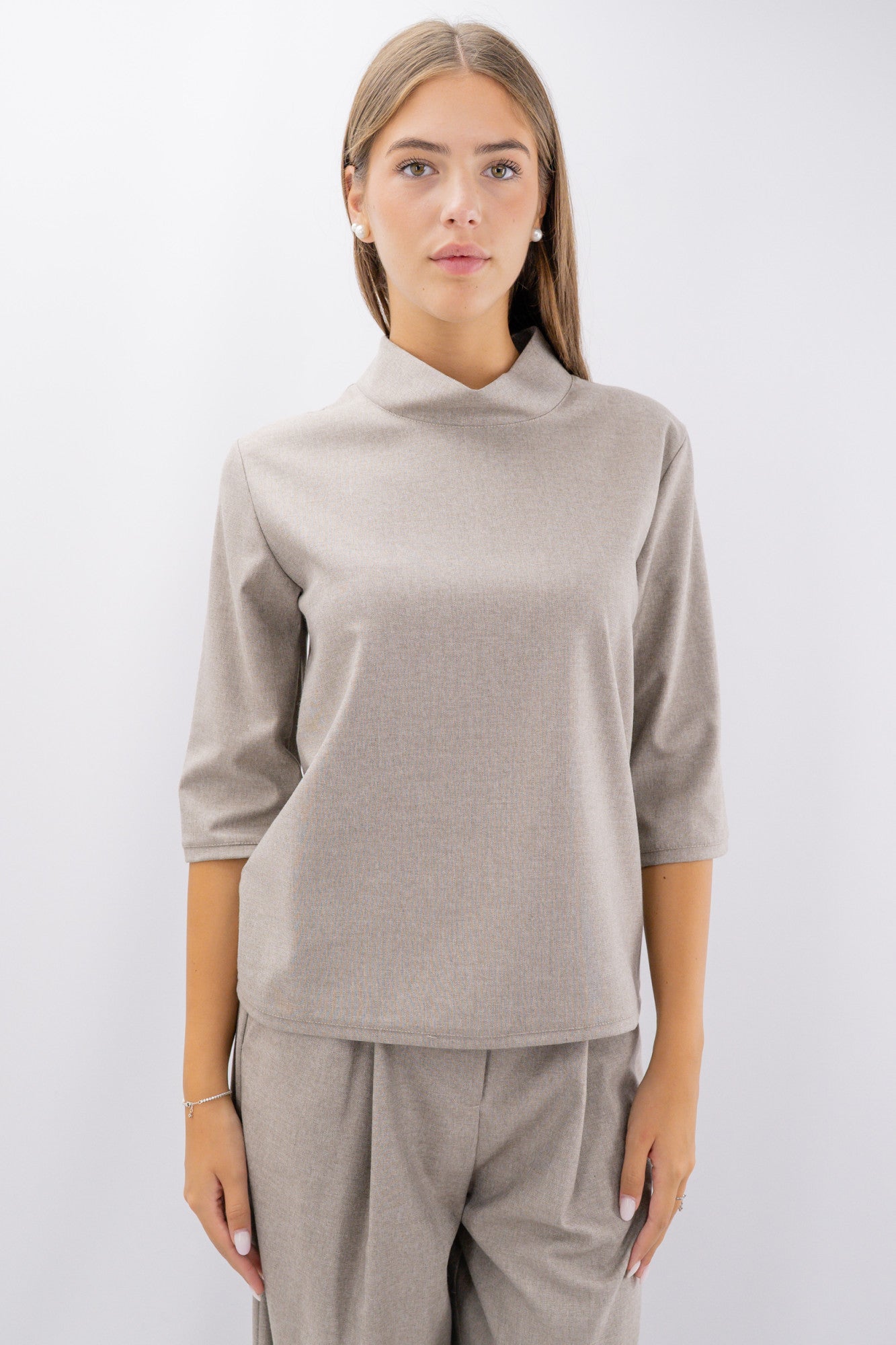 Blusa con collo rialzato e manica a tre quarti.