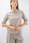 Blusa con collo rialzato e manica a tre quarti.