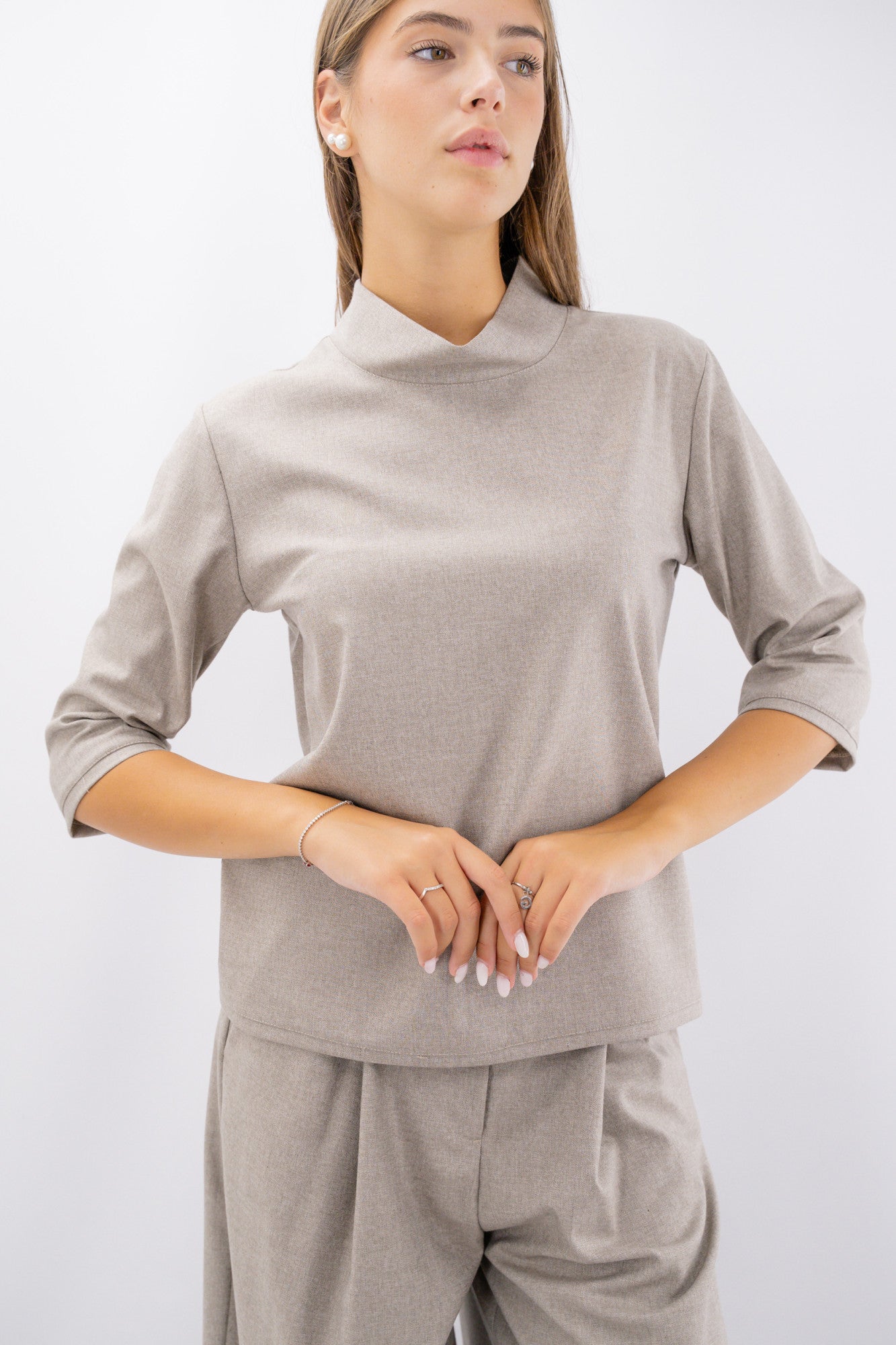 Blusa con collo rialzato e manica a tre quarti.