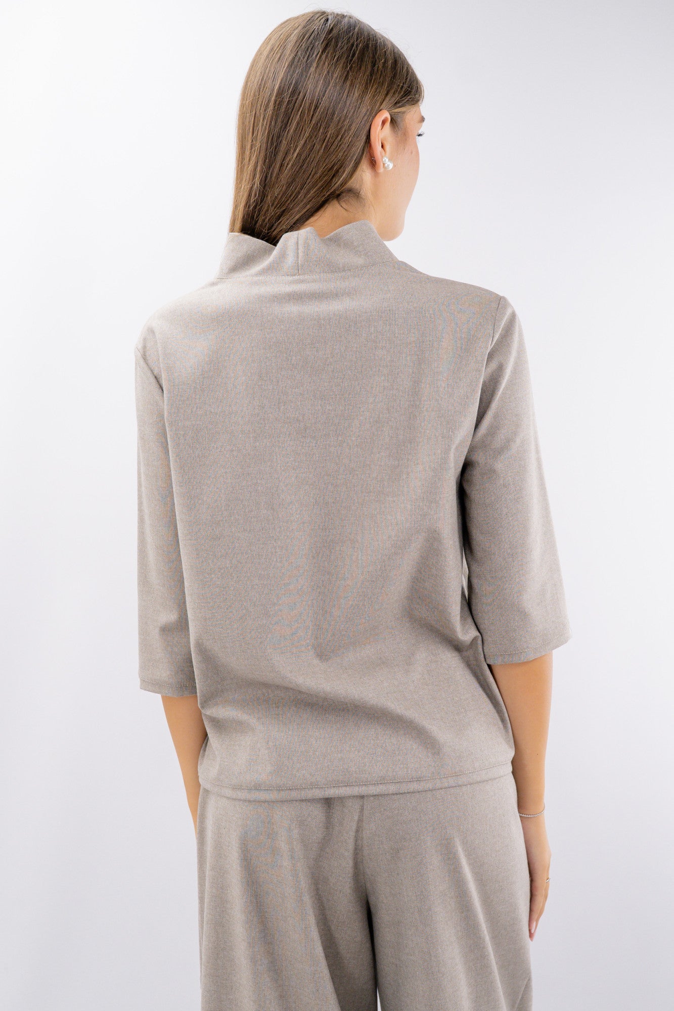 Blusa con collo rialzato e manica a tre quarti.